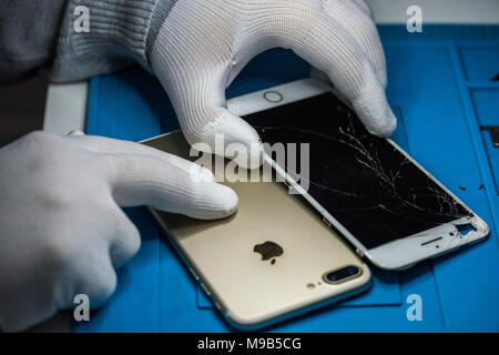 Reparing electronics devices, hands and tools, mobiles and computers. IPhone repairing Stock Photo