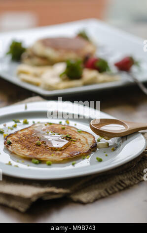 Stack of Turkish -style pancakes with pistachio and honey Stock Photo