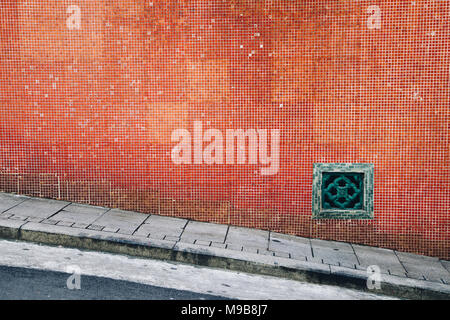 Old red tile wall and sloping street in Hong Kong Stock Photo