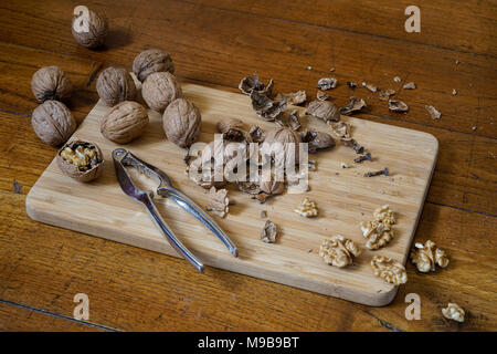 Some walnuts split on a wooden table Stock Photo