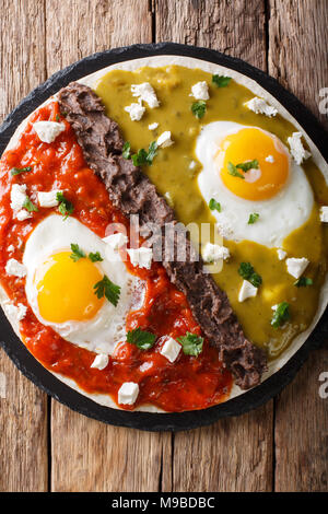 huevos divorciados, fried eggs on corn tortillas with two salsas, mexican breakfast. Vertical top view from above Stock Photo