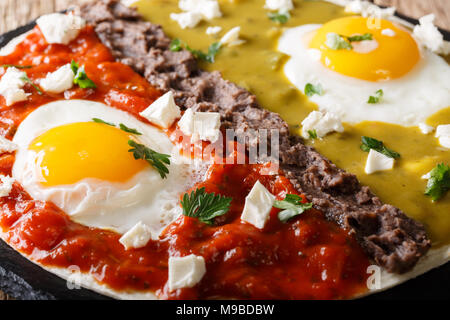 huevos divorciados, fried eggs on corn tortillas with two salsas macro, mexican breakfast Stock Photo