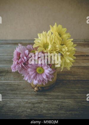 Retro image, pink and yellow flower in bamboo vase on table, vintage background, Stock Photo