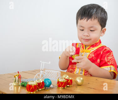 A Boy wearing Chinese playing Christmas toy on table, Stock Photo