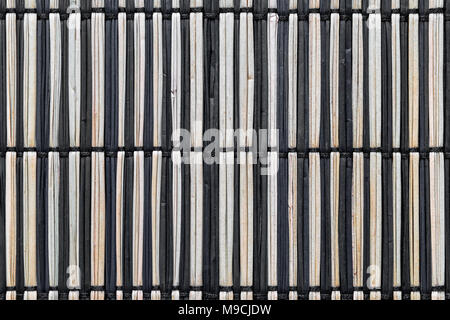 Black and brown straw mat background surface. Straws tide between each other with black rope Stock Photo