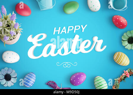 Happy Easter greeting text on blue background surrounded with colorful eggs and decorations. Stock Photo