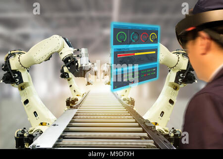 iot industry 4.0 concept,industrial engineer(blurred) using smart glasses with augmented mixed with virtual reality technology to monitoring machine i Stock Photo