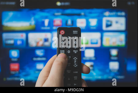Male hand holding TV remote control. Smart TV. Stock Photo