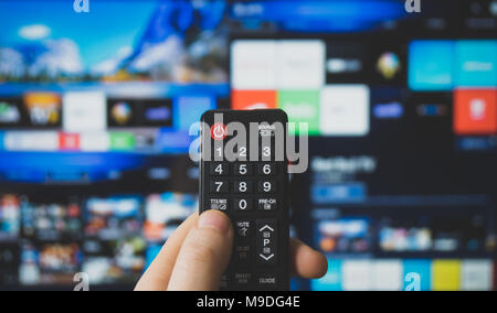 Male hand holding TV remote control. Smart TV. Stock Photo