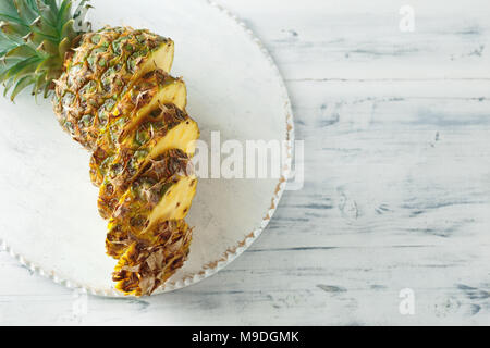 Fresh sliced pineapple on a white wooden cutting board. Top view Stock Photo
