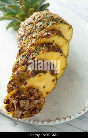 Fresh sliced pineapple on a white wooden cutting board. Top view Stock Photo