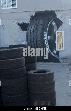 piles of tyres and three dimensional tyre mural outside car repair shop in the old town area of paphos, cyprus, europe Stock Photo