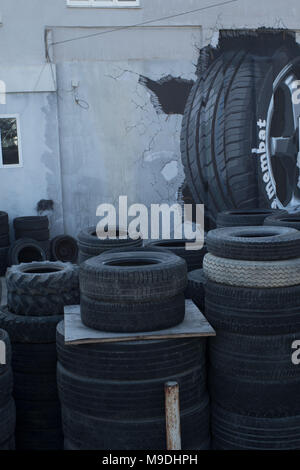 piles of tyres and three dimensional tyre mural outside car repair shop in the old town area of paphos, cyprus, europe Stock Photo
