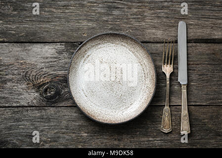 Table setting with vintage silverware or cutlery and empty plate on rustic wood. Top view with copy space for text Stock Photo