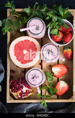 Fresh smoothies of strawberry, grapefruit and pomegranate in bottles. Top view. Healthy lifestyle, vegan, vegetarian, fitness concept Stock Photo