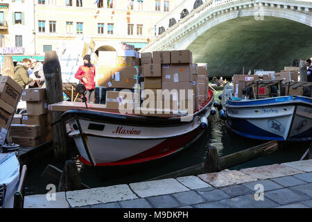 Venetian Delivery Barges sit on the Grand Canal next to the Rialto Bridge in the morning ahead of their daily rounds Stock Photo