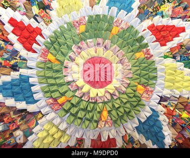 Handmade circular rug with floral pattern in patchwork style. From multi-colored rags of green, red, yellow, blue, orange, pink, white colors Stock Photo