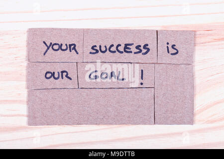 Your success is our goal! written with black felt-tip pen in cut-out cardboard placed on wood. Stock Photo