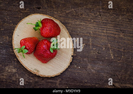 Red berry strawberry on old rustic wooden background. Background from freshly harvested strawberries with space for text. Strawberry background. Direc Stock Photo