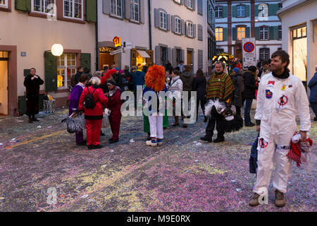 Baeumleingasse, Basel, Switzerland - February 20th, 2018. Basel carnival. Bustling carnival life in a side street covered with colorful confetti Stock Photo