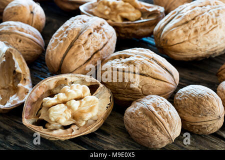 Closeup of whole and broken walnuts on old wood Stock Photo