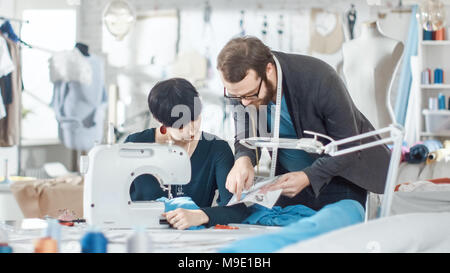 Male and Female fashion, designer, s are Working on Tailored Mannequin Wearing Clothes. They Also Use smartphone. In Their Studio Sewing Machine Stock Photo