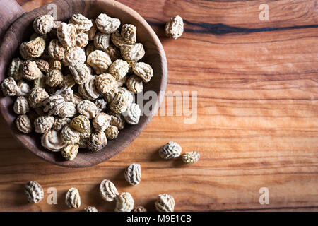 Nasturtium (Tropaeolum majus) seeds on a wooden spoon with copy space Stock Photo