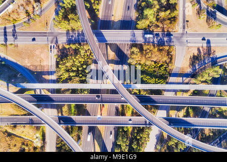 Elevated aerial top down view over multi-lever intersection of two large highways in Sydney - M4 and M7. Tangled light horse interchange with lots of  Stock Photo