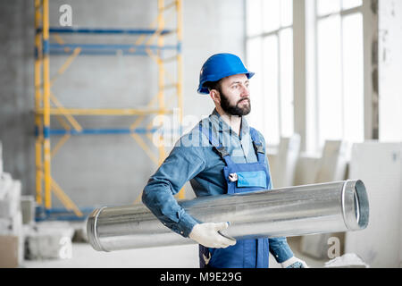 Builder with pipe indoors Stock Photo