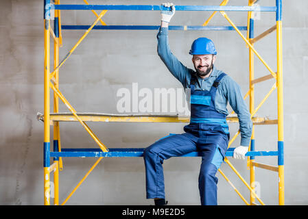 Builder on the scaffolding indoors Stock Photo