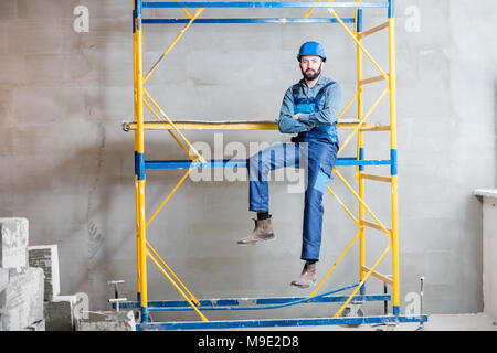 Builder on the scaffolding indoors Stock Photo