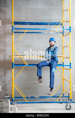 Builder on the scaffolding indoors Stock Photo