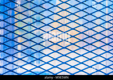 Dark blue metal wire protective diagonal grid or mesh, soft middle tones colorful background Stock Photo