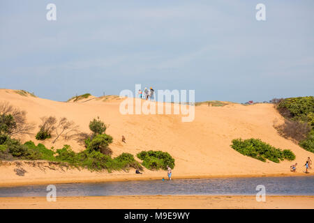 People at the top of a sand dune at Narrabeen lagoon, Sydney,Australia Stock Photo