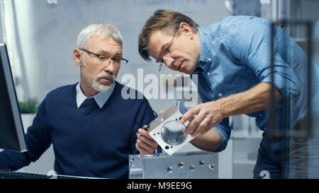 Two Senior Engineers Discuss Important Technical Component. Both are Experienced and Wise. Their Office Looks Modern and Bright. Stock Photo