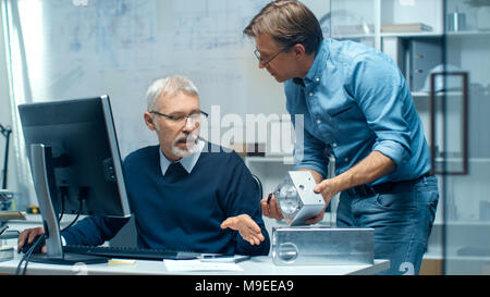 Two Senior Engineers Discuss Important Technical Component. Both are Experienced and Wise. Their Office Looks Modern and Bright. Stock Photo