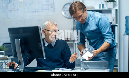Two Senior Engineers Discuss Important Technical Components, Joining Them Together. Both are Experienced and Wise. Their Office Looks Modern Stock Photo