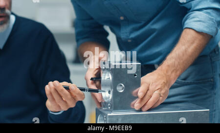 Close-up Shot of a Two Senior Engineers Discuss Important Technical Components, Joining Them Together. Both are Experienced and Wise. Stock Photo