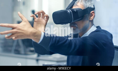 IT Engineer Working with Virtual Reality Headset On. He Works in His Modern and Minimalistic Office. VR helmet. Stock Photo