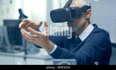 IT Engineer Working with Virtual Reality Headset On. He Works in His Modern and Minimalistic Office. VR helmet. Stock Photo