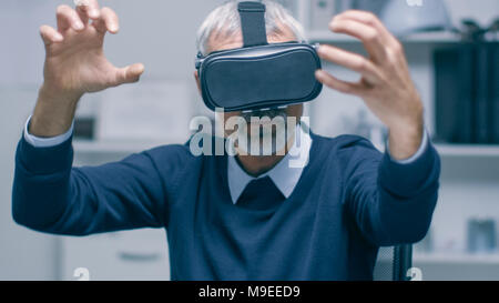 IT Engineer Working with Virtual Reality Headset On. He Works in His Modern and Minimalistic Office. VR helmet. Stock Photo