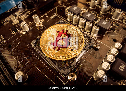 Gold Bit Coin BTC coins on the motherboard. Bitcoin is a worldwide cryptocurrency and digital payment system called the first decentralized digital cu Stock Photo