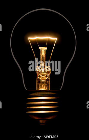 Photo of silhouette of incandescent filament bulbs on a black background. Detail of a lit European bulb. Product photo flashbulb. Stock Photo