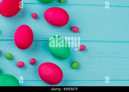 Easter dyed eggs, copy space. Painted Easter eggs and candies on blue background. How to dye Easter eggs. Stock Photo