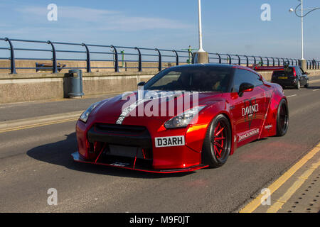 Red Nissan GT-R Davinci sports car at the North-West Supercar event as cars arrive in the coastal resort of Southport. SuperCars are bumper to bumper on the seafront esplanade as modern classics, sports cars & Canon Run car enthusiasts enjoy a motoring day out.