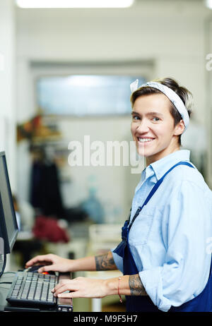 Female operator typing on computer in printing house Stock Photo