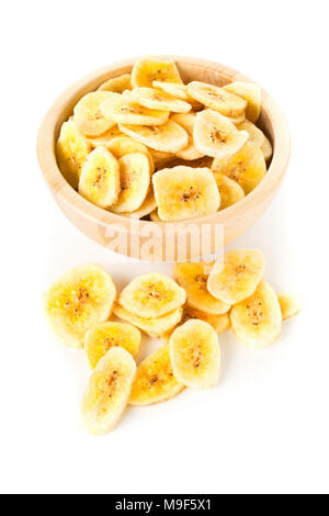 Heap of dried banana chips snack in wooden bowl over white background Stock Photo
