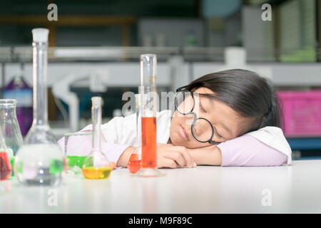 cute chemistry students sleeping after doing science experiment with equipment and wait reaction after mix chemical in laboratory, working of scientis Stock Photo