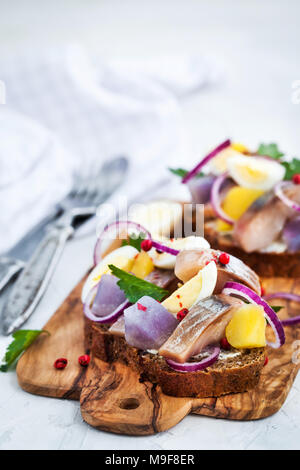 Open sandwich (smorrebrod) with herring, onion, potato and eggs Stock Photo