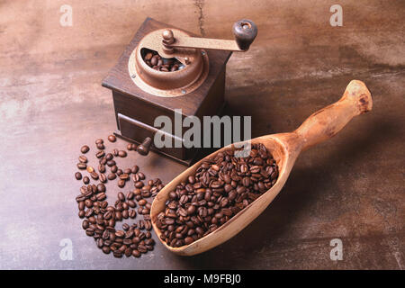 coffee beans in a wooden scoop and coffee grinder on dark stone table. Stock Photo